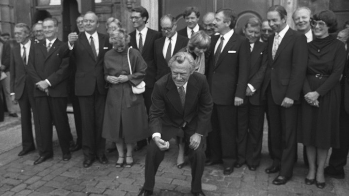 1982: Statsminister Poul Schlüter (K) præsenterer sin nye regering på Amalienborg Slotsplads. Her bøjer han sig for at samle lykkeskillinger kastet af de omkringstående op.