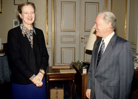 En storsmilende statsminister, Poul Schlüter (K), mødes med dronning Margrethe til det ugentlige orienteringsmøde, 1990.