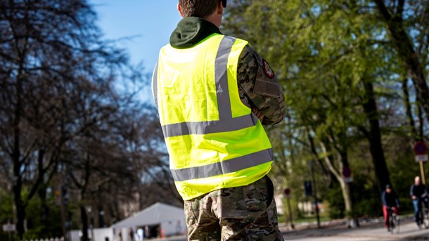 Soldat fra Livgarden står vagt foran testcenteret i Fælledparken i København.