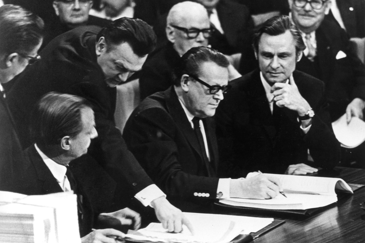 Jens Christensen (til højre) ser på, mens statsminister Jens Otto Krag underskriver Romtraktaten i Bruxelles i januar 1972.