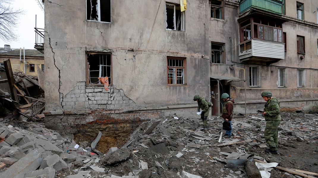 Efterforskere der arbejder uden for en skadet boligblok i en russisk-kontrolleret del af Ukraine.
