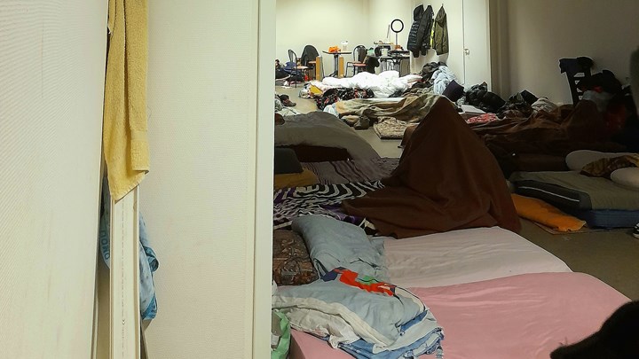 En mand gemmer sig under et tæppe, da han ikke vil genkendes som hjemløs asylansøger.