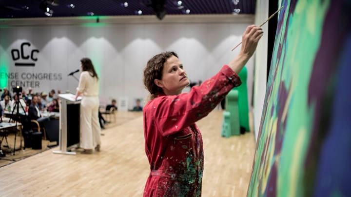 Leah Robb var hyret som årets 'landsmødekunstner'. I løbet ad weekenden stod hun på scenen i en rød dragt imens hun malede et grønt billede inspireret af weekendens debatter. 