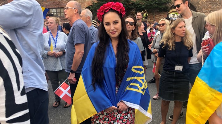 Ukrainskfødte Anna Versal arbejder til daglig med ukrainske flygtninge i Gentofte Kommune. Hun er troppet op for at vise sin støtte til de ukrainere, der lige nu får ødelagt deres hjem. På hovedet bærer hun en traditionel blomsterkrans, som er et nationalt symbol for kvinder.