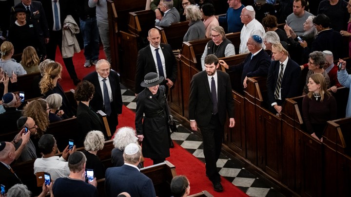 Dronningen bliver ført ind i synagogen af overrabbiner i Danmark, Jair Melchior, og Henri Goldstein, formand i Det Jødiske Samfund i Danmark.