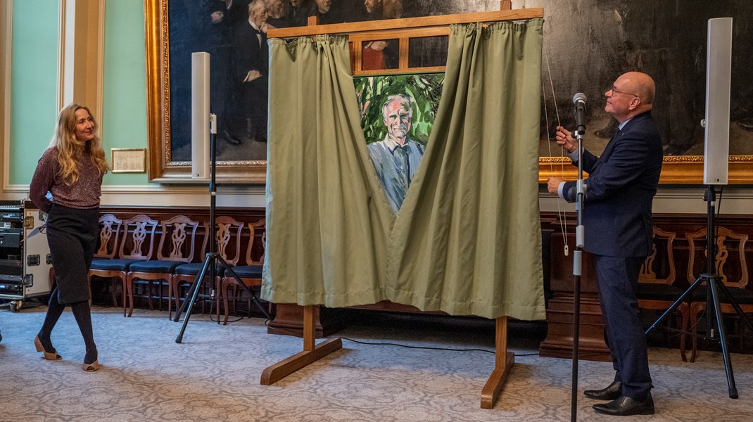 Søren Gade trækker gardinet fra og afslører portrættet af Bertel Haarder. Til venstre står kunster Maria Wandel.