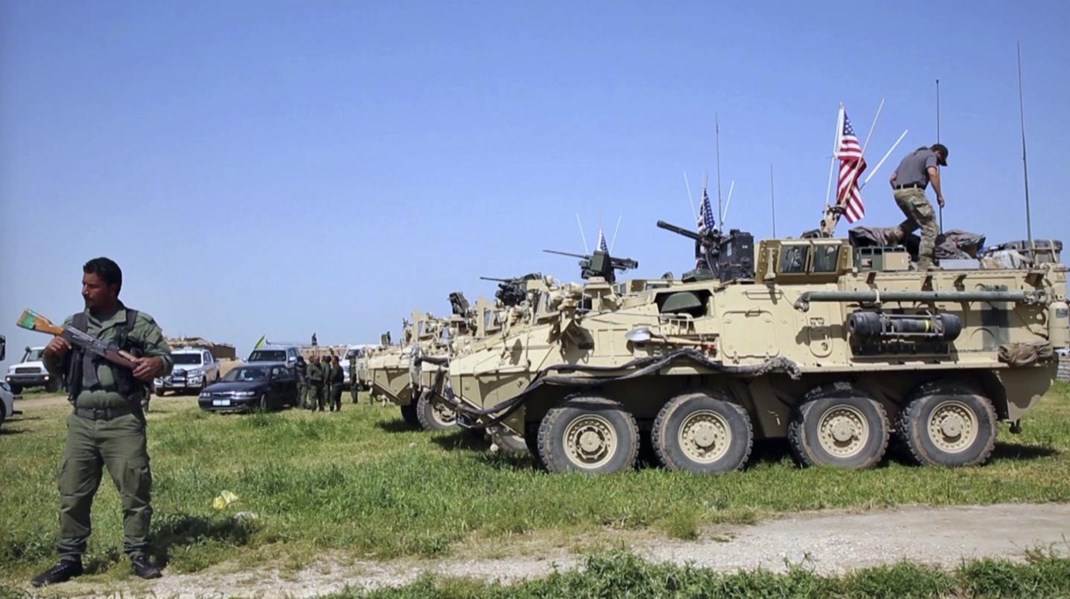 YPG-soldat holder vagt ved pansrede amerikanske køretøjer i
krigen mod Islamisk Stat. Det er YPG-militsen, Serdal Benli nu bliver anklaget
for at støtte.