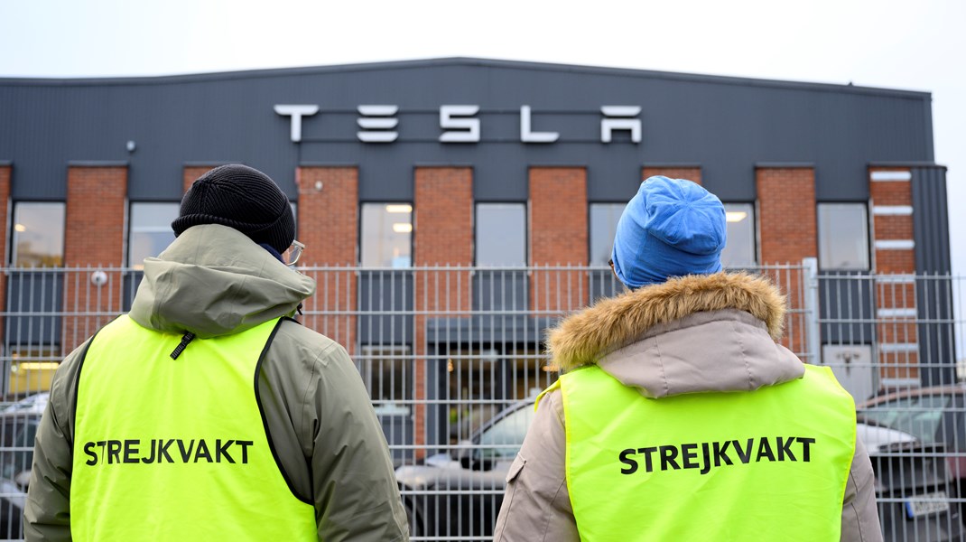 Arturo Vasquez Sandoval og David Risberg holder strejkevagt foran Teslas servicecenter i Segeltorp nær Stockholm i Sverige.